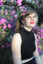 image of the author seated in front of a pink azalea bush